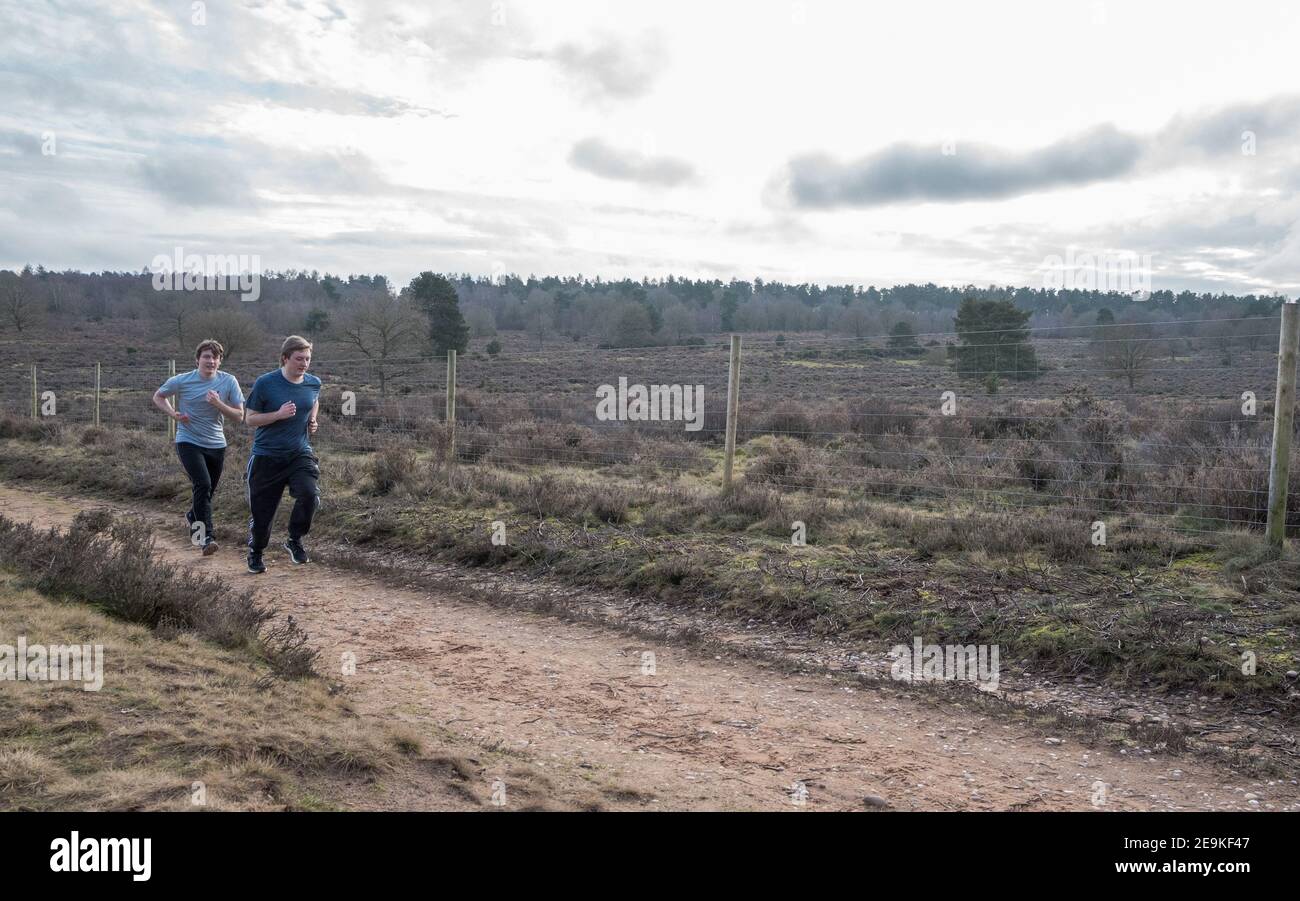 Zwei männliche Erwachsene laufen auf dem Land. Stockfoto