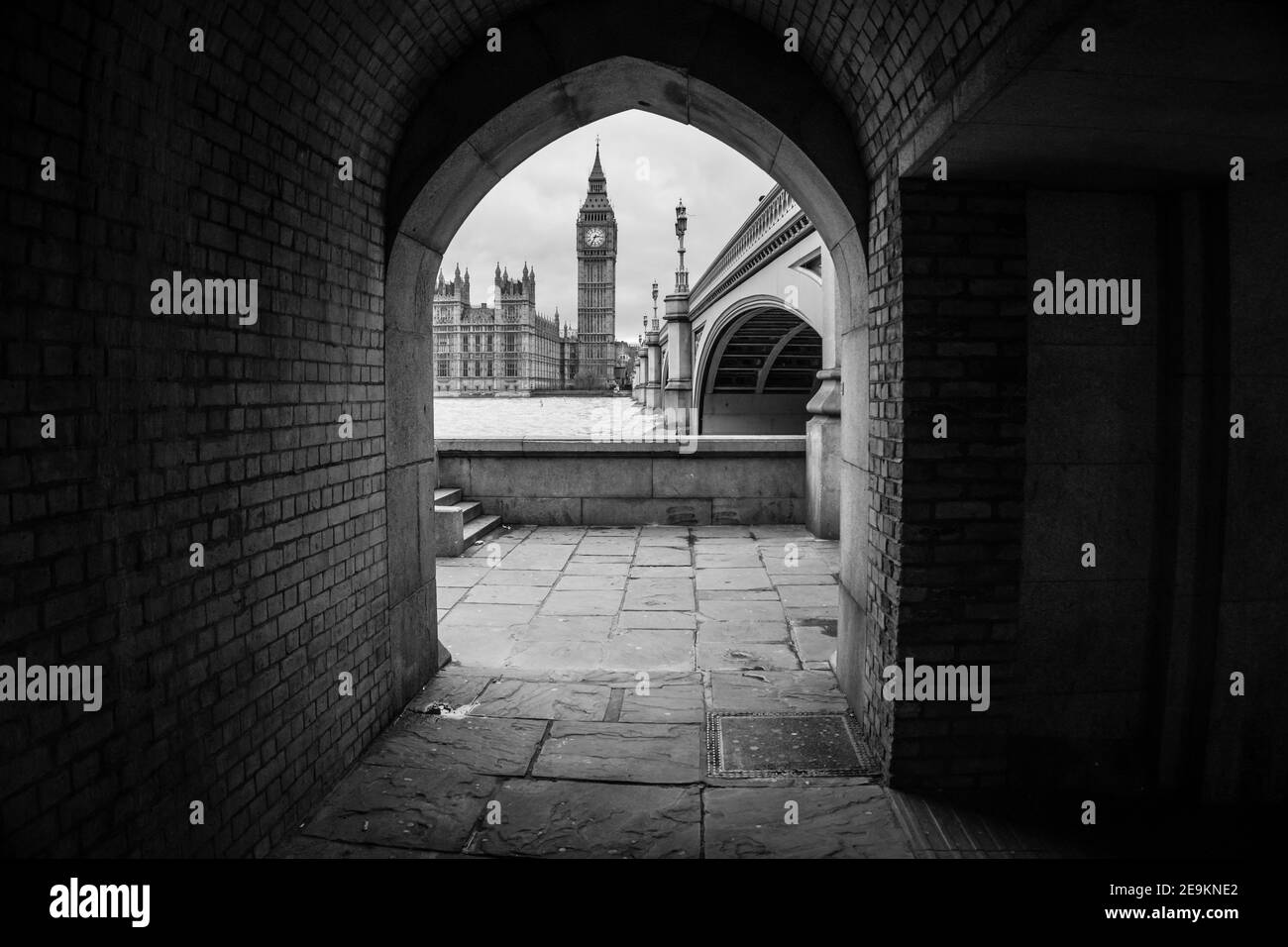 Schwarz-Weiß-Ansicht von Big Ben und dem Palast von Westminster von einem Durchgang unter Westminster Bridge, London, England Stockfoto