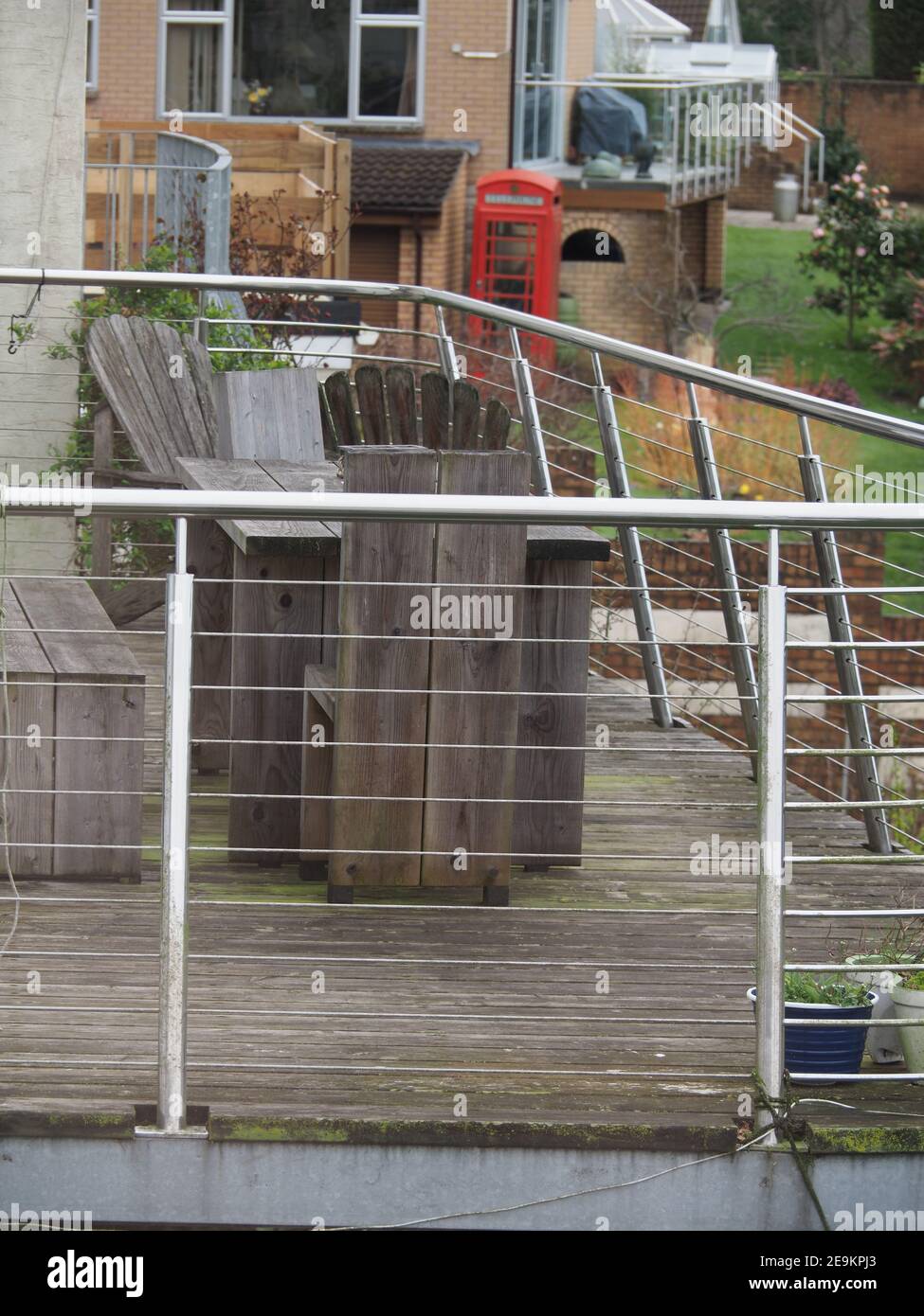 Ein Holzbalkon mit Chromstahl Balkongeländer und Holz Gartenmöbel Stockfoto