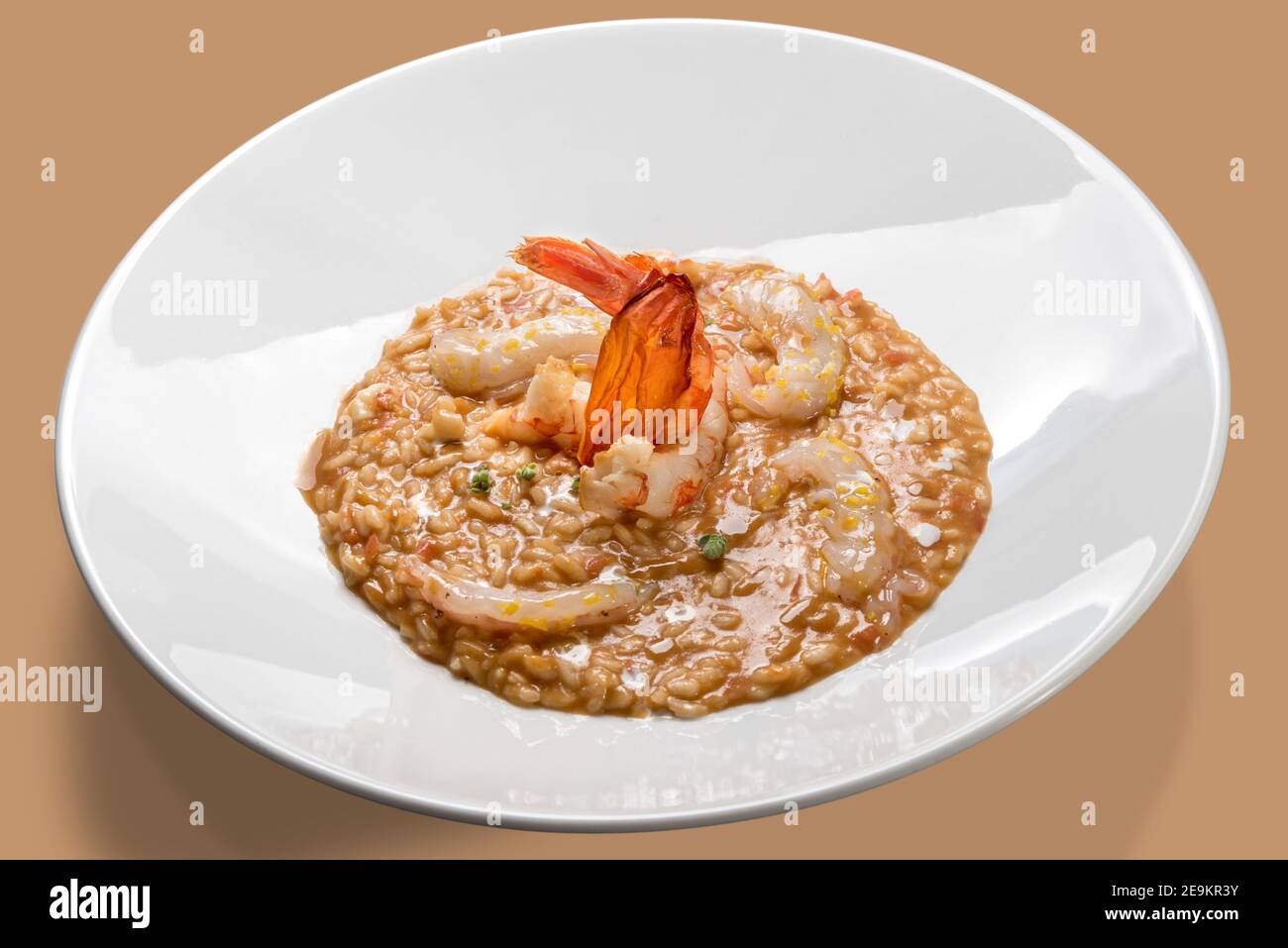 Garnelenrisotto, traditionelles italienisches Gericht 'Risotto con gamberi' in weißer Schale Auf farbigem Hintergrund.Nahaufnahme Stockfoto