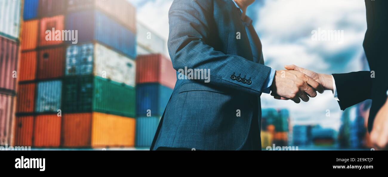 Export- und Importgeschäft. Geschäftsleute Handshake am industriellen Container-Terminal. Seeverkehr und Logistik-Konzept Stockfoto