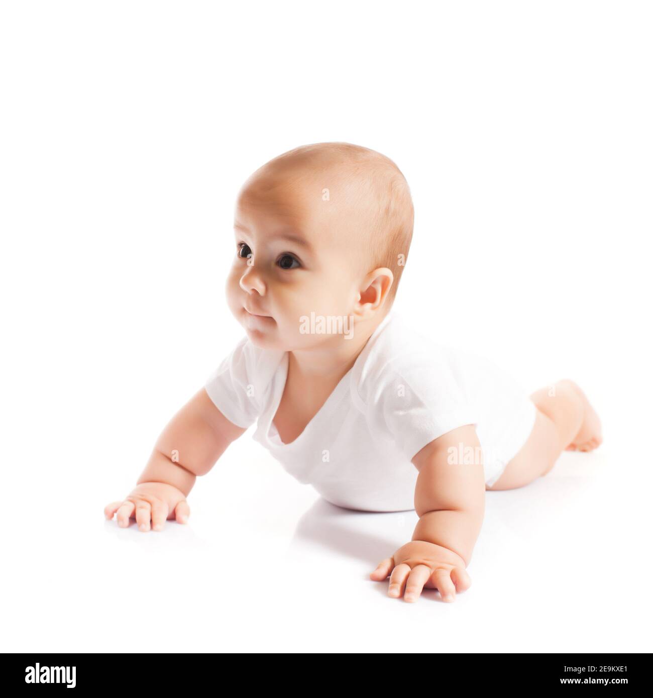 Liebenswert krabbelnd Baby Junge schaut beiseite auf weiß Stockfoto