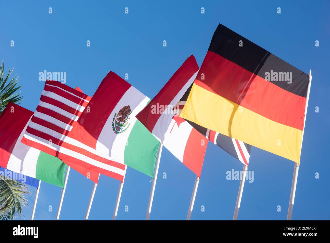 Die Nationalflaggen Italiens, Englands, Kanadas, Mexikos, der Vereinigten Staaten und Deutschlands fliegen vor blauem Himmel Stockfoto