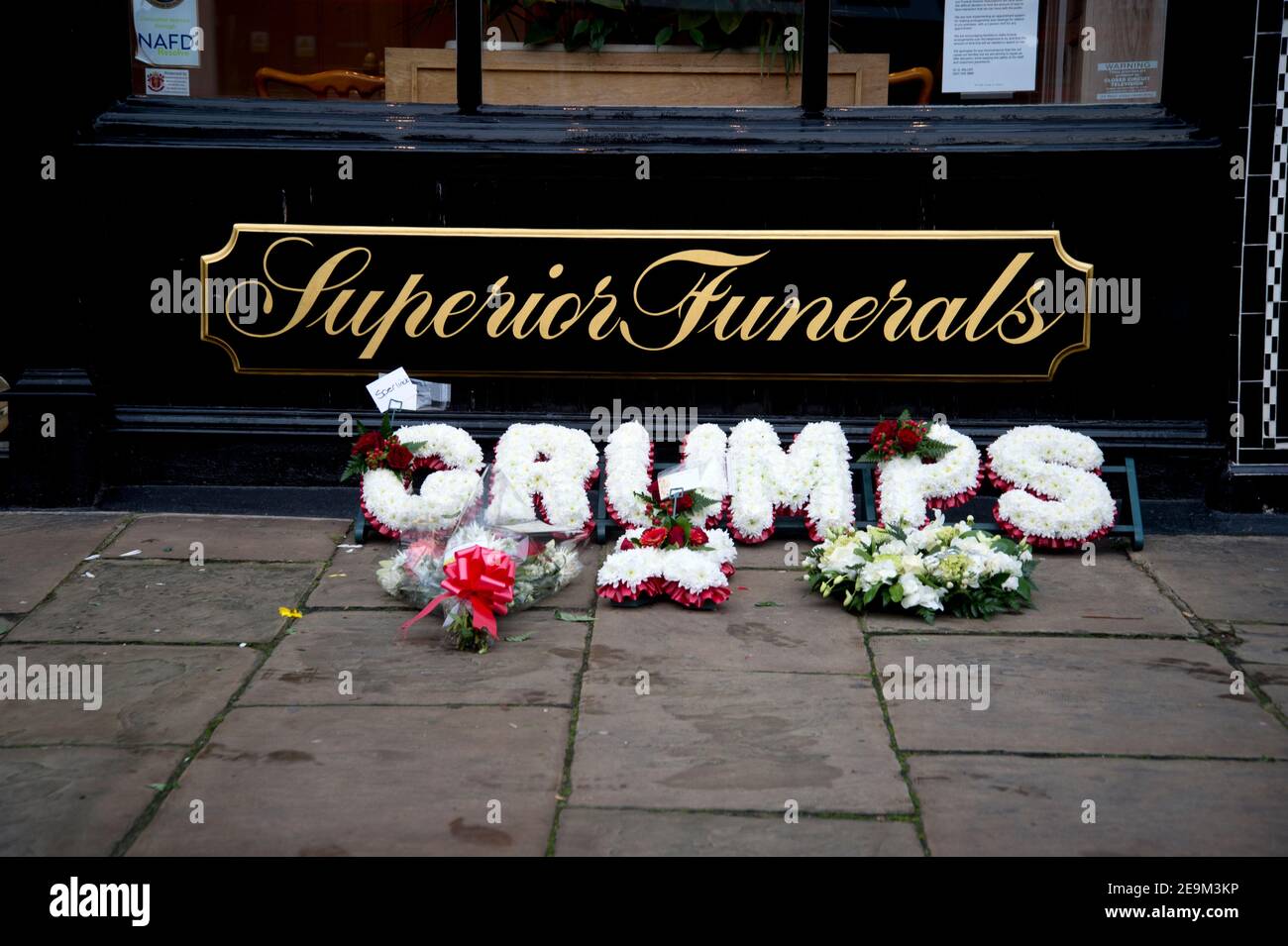 London, Islington. Bestattungsinstitut. Blumen auf dem Bürgersteig mit Kranz mit der Aufschrift "Grumps". Stockfoto