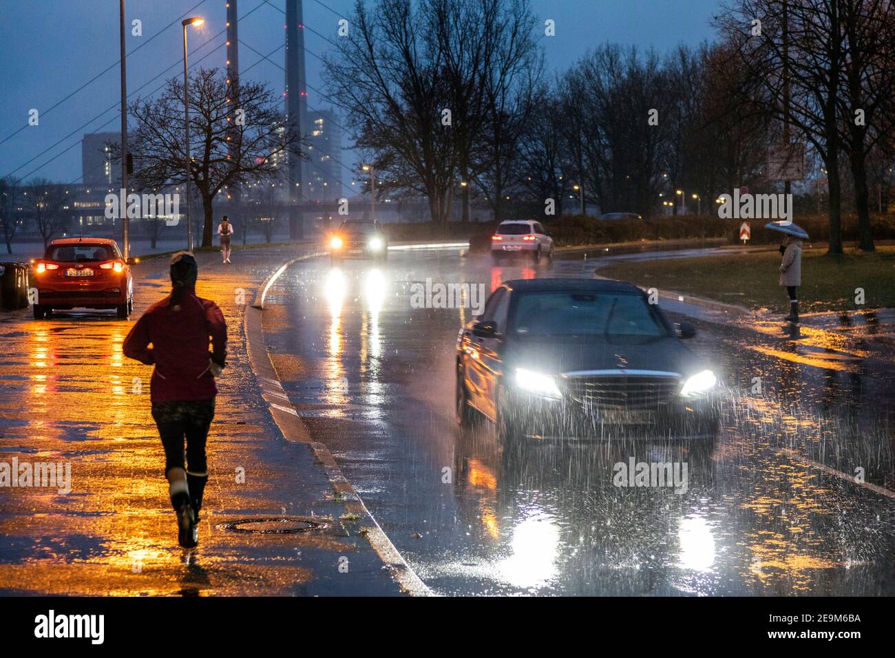 Starker Regen am Abend macht die Straßenverhältnisse in Düsseldorf am Rhein, im Hintergrund die Rheinkniebrucke und den Fernsehturm schwierig Stockfoto