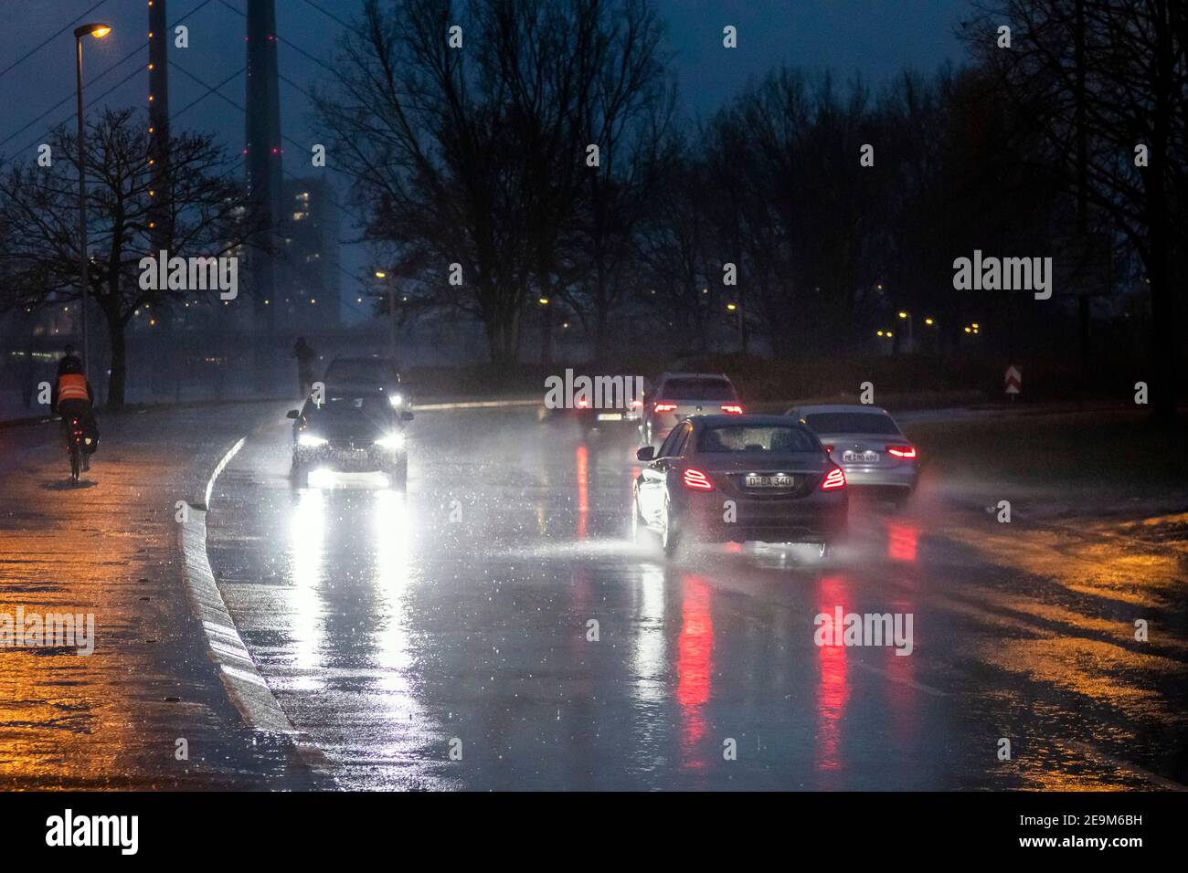 Starker Regen am Abend macht die Straßenverhältnisse in Düsseldorf am Rhein, im Hintergrund die Rheinkniebrucke und den Fernsehturm schwierig Stockfoto