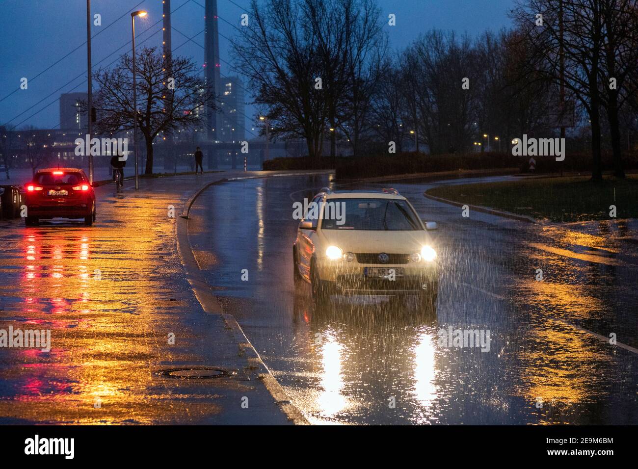 Starker Regen am Abend macht die Straßenverhältnisse in Düsseldorf am Rhein, im Hintergrund die Rheinkniebrucke und den Fernsehturm schwierig Stockfoto