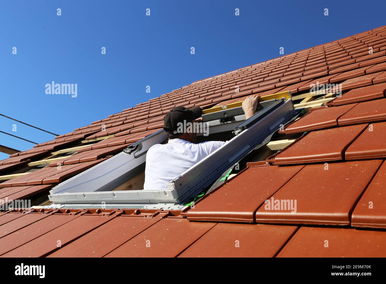 Dachdecker installiert ein Dachfenster (Modell freigegeben Stockfotografie  - Alamy