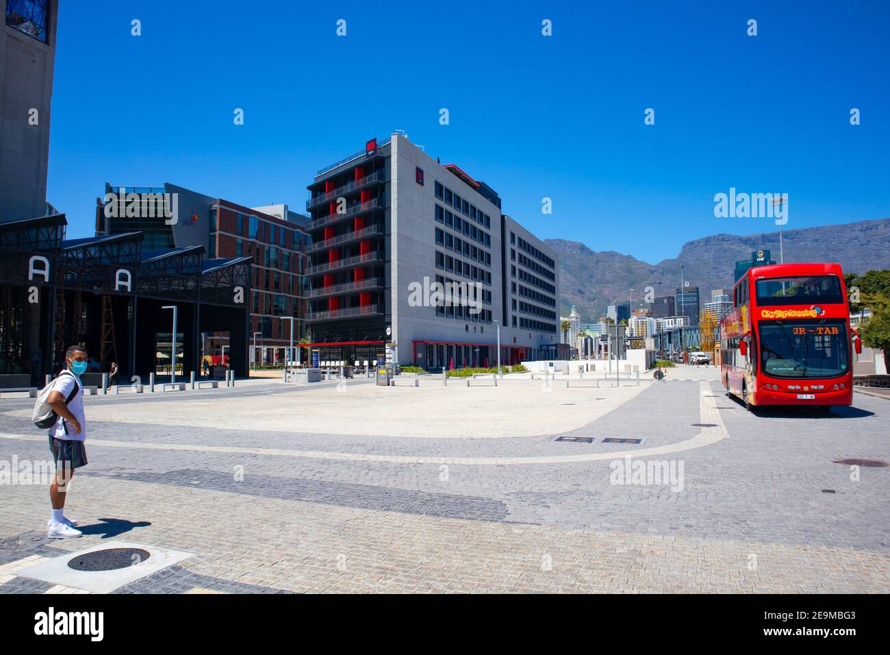 Waterfront- Kapstadt, Südafrika - 03-02-2021 Zeitz Museum of Contemporary Art Africa Building, City Sight Seeing Bus und Menschen in Gesichtsmasken. Stockfoto