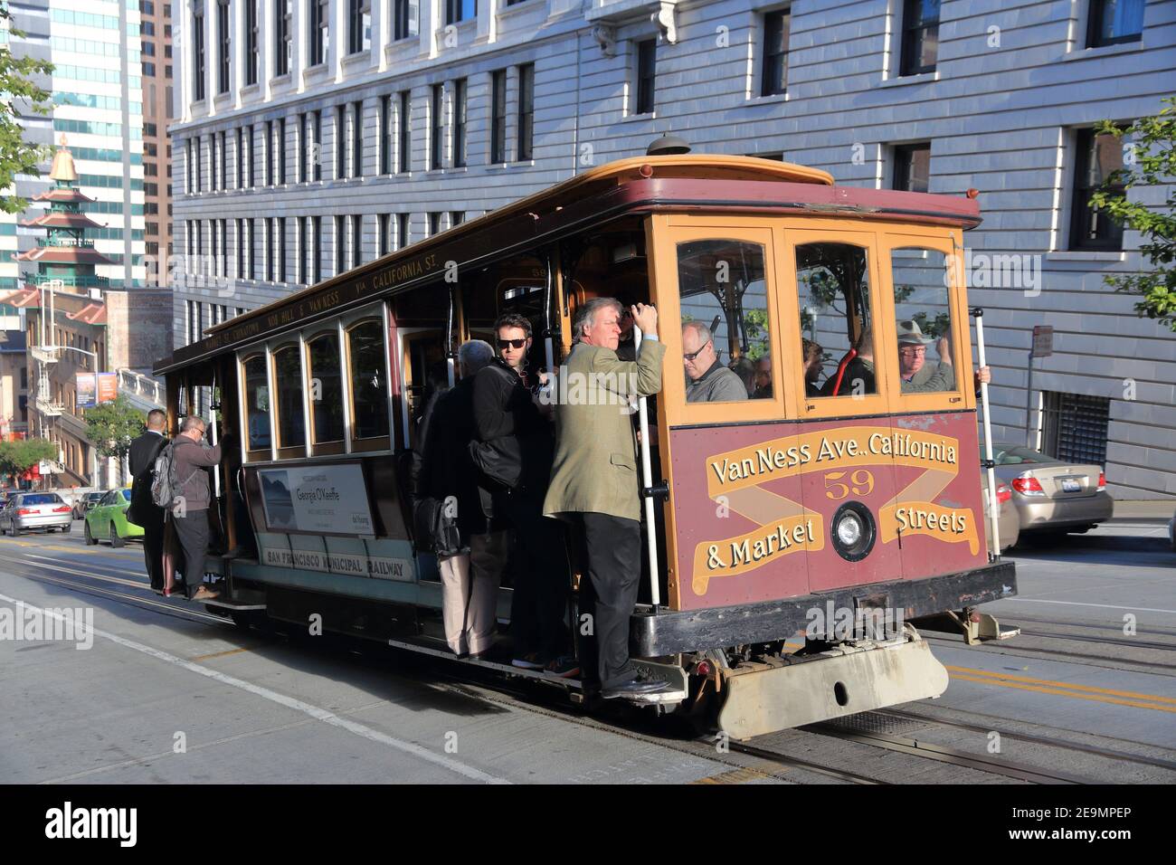 SAN FRANCISCO, USA - 9. APRIL 2014: Menschen fahren historische Seilbahn in San Francisco, USA. Berühmte SF Straßenbahnen in Betrieb genommen im Jahr 1878. Alcatraz kann b Stockfoto