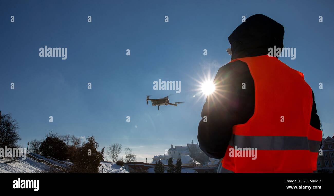 Nahaufnahme des flaying Quadrocopter dron und Pilot Siluette in Sonnenuntergang Licht und blauen Himmel Hintergrund, man fliegt eine Drohne in der Stadt mit einem contr Stockfoto