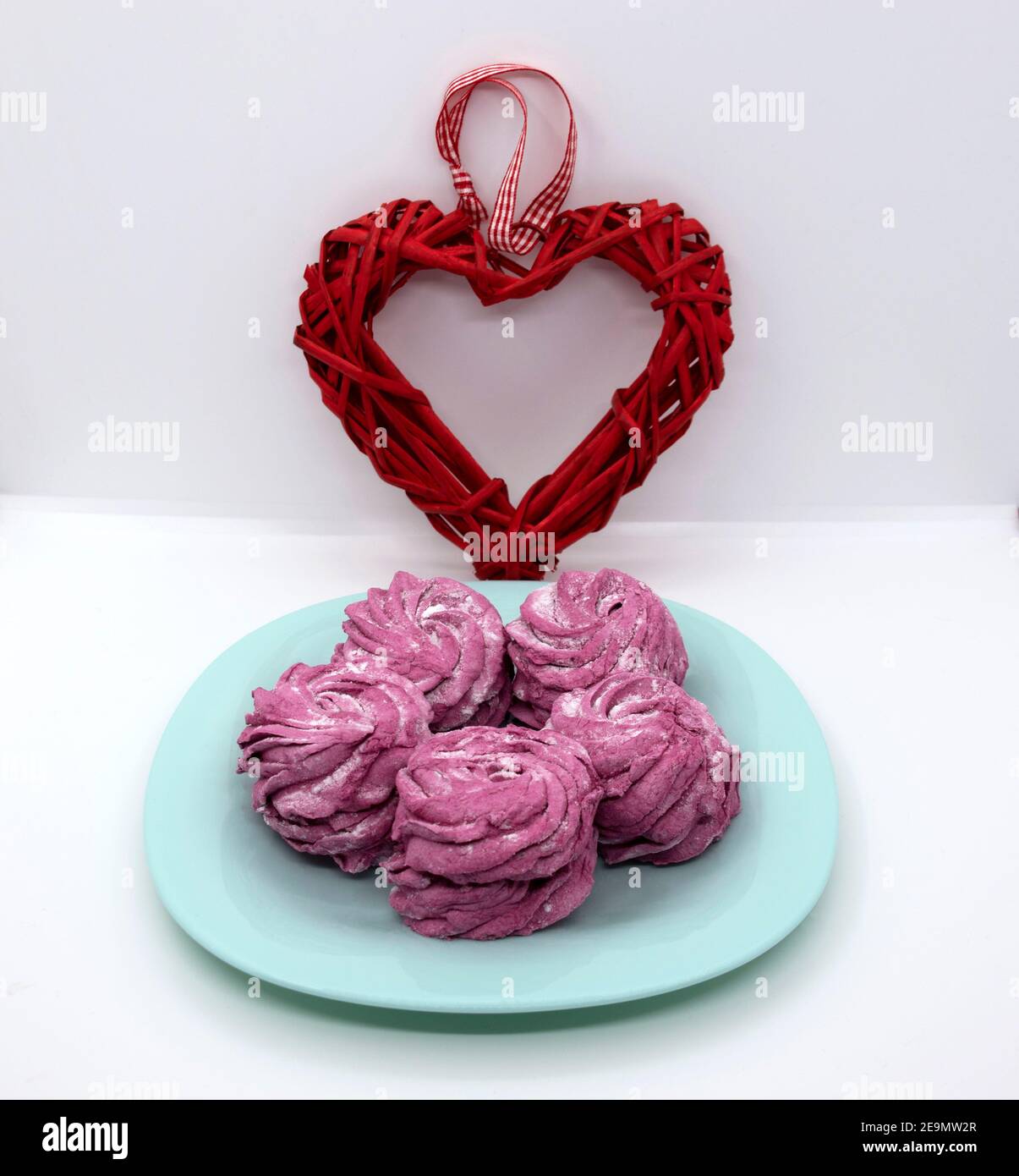 Auf einer türkisfarbenen Untertasse, Himbeer Marshmallows zum Dessert mit Herz zum Valentinstag. Stockfoto