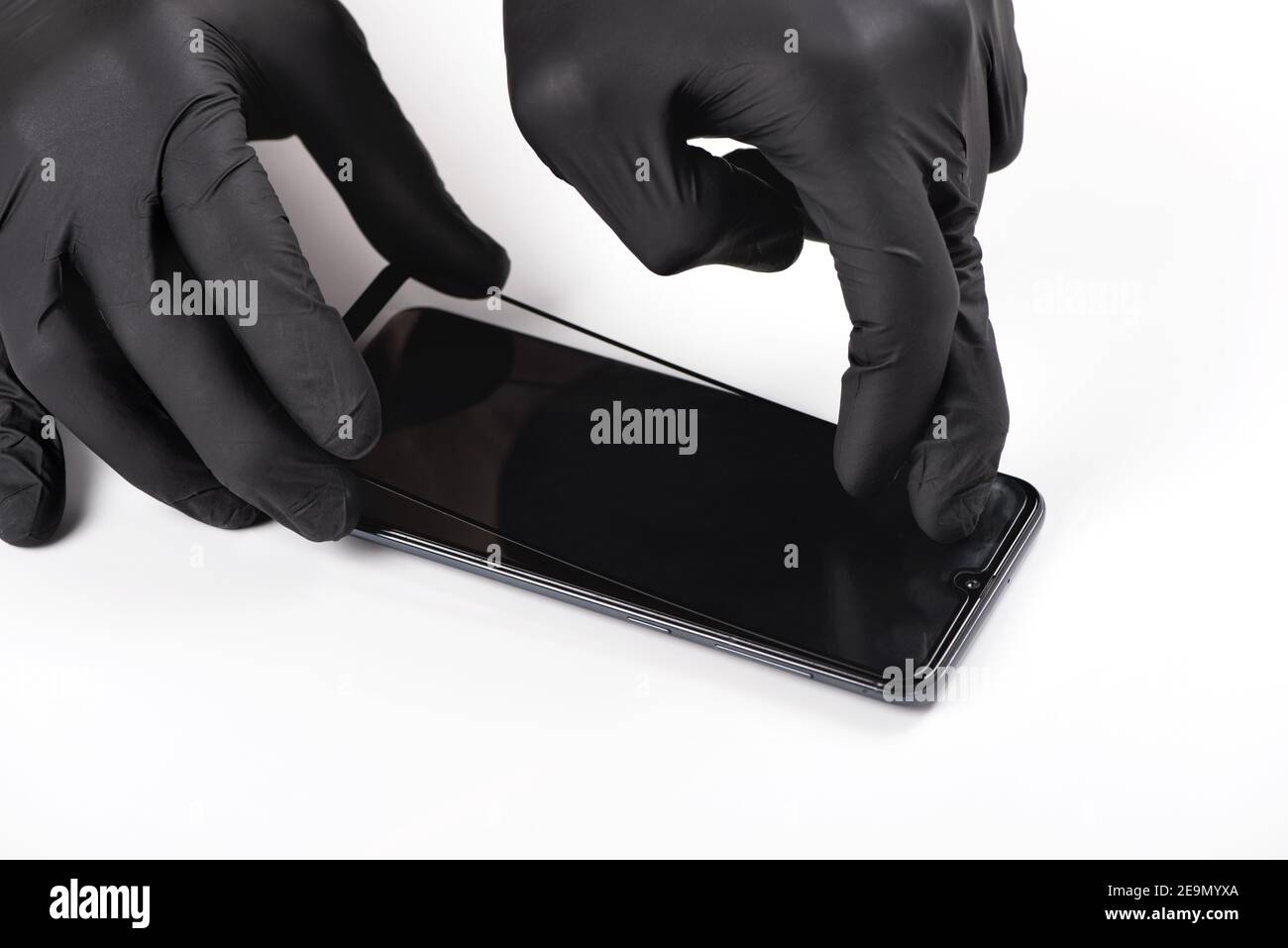 Ein Mann ist ein Schutzglas auf dem Bildschirm eines Smartphones. Stockfoto