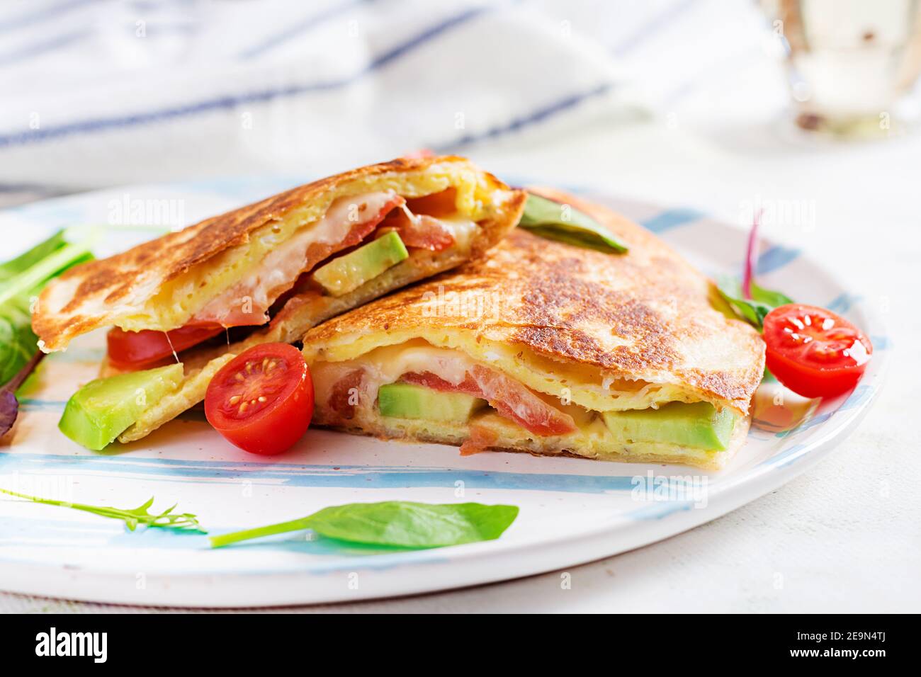 Leckeres Frühstück mit Quesadilla und Eiern. Mexikanische Küche. Trendgerichte mit Omelette, Käse, Tomaten, Avocado. Einfaches und leichtes Mittagessen. Stockfoto