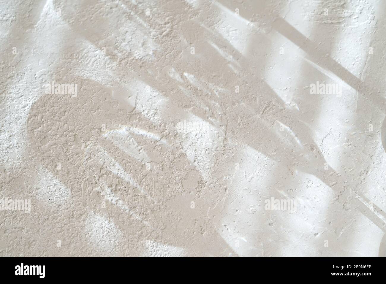 Weiße Beton-ähnliche Hintergrundstruktur mit Schatten von Jalousien und Gläsern, mit Kopierraum Stockfoto