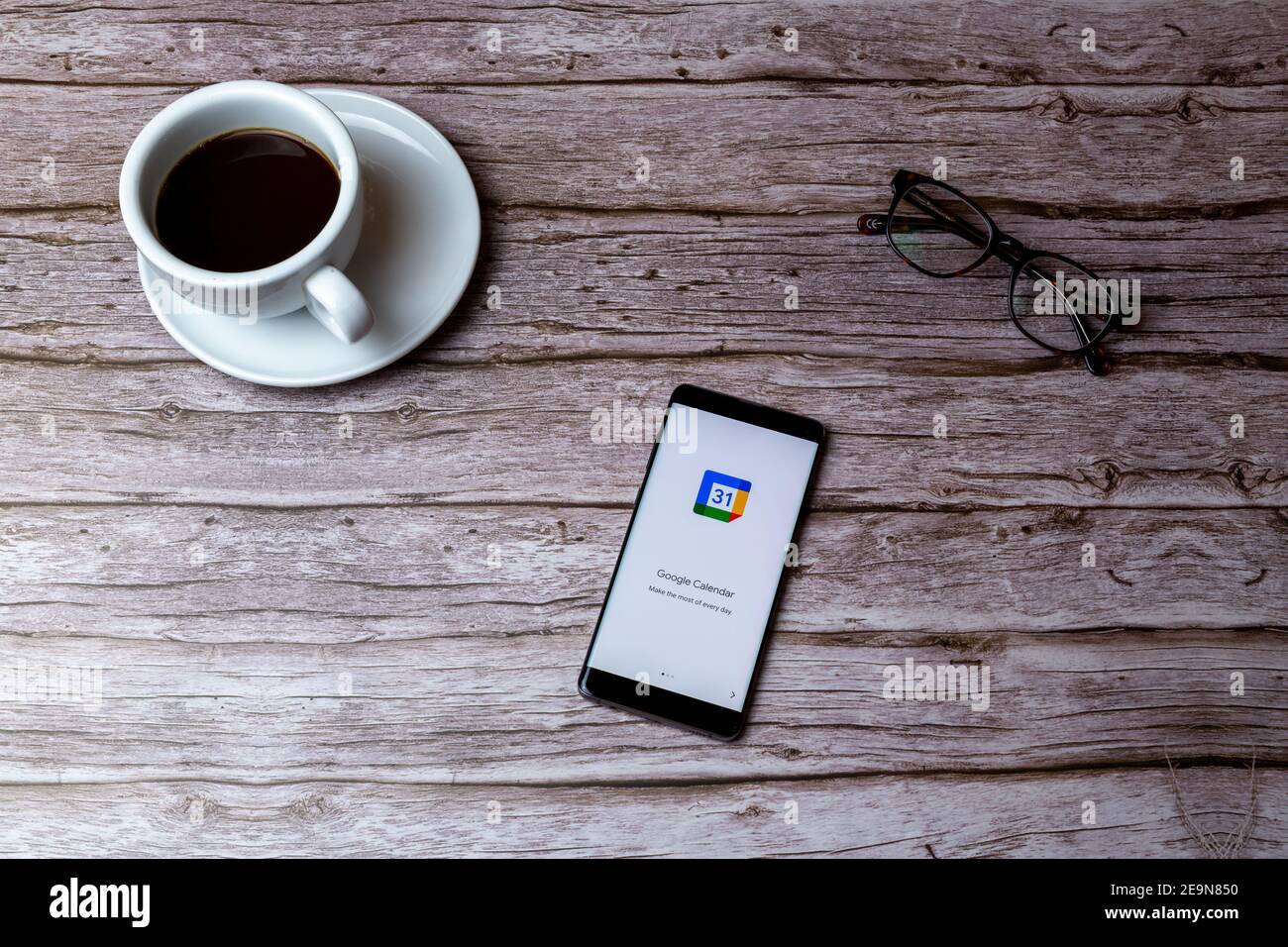 Ein Handy oder Handy auf einem Holz gelegt Tisch oder Schreibtisch mit der Google Calendar App geöffnet Stockfoto