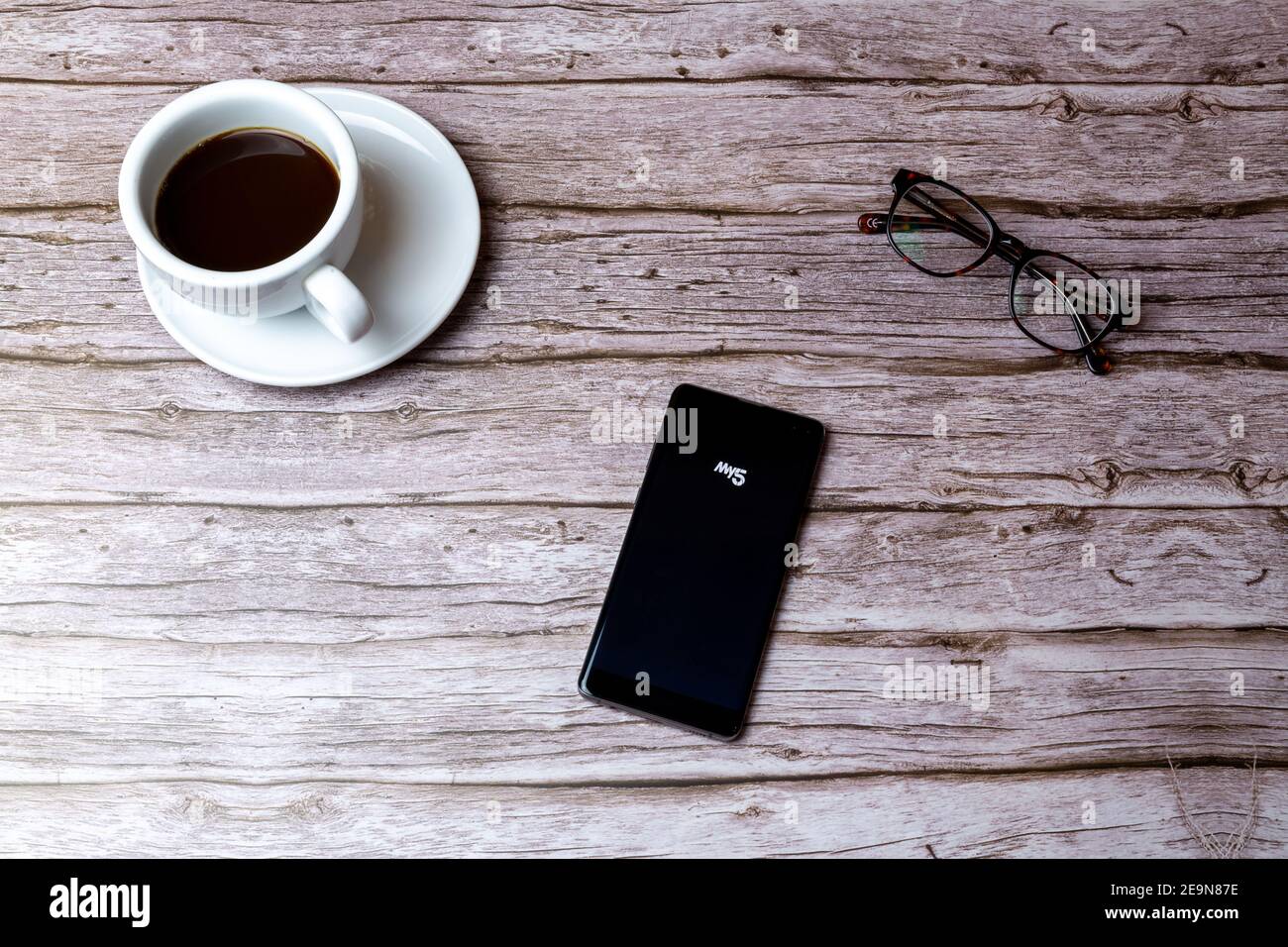 Ein Handy oder Handy auf einem Holz gelegt Tisch oder Schreibtisch mit geöffneter TV-App My5 Stockfoto