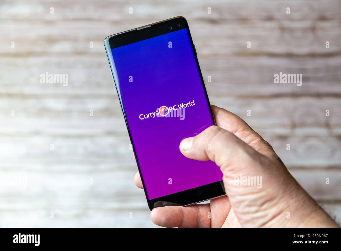 Ein Mobiltelefon oder Mobiltelefon, das/das gehalten wird, zeigt das an Currys PC World App auf dem Bildschirm geöffnet Stockfoto