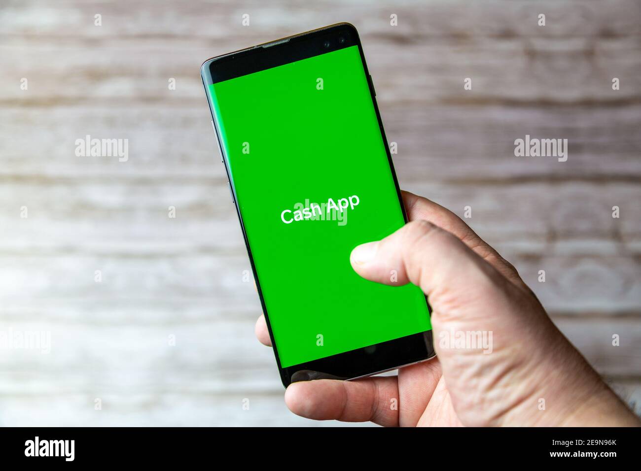 Ein Mobiltelefon oder Mobiltelefon, das/das gehalten wird, zeigt das an Cash App auf dem Bildschirm geöffnet Stockfoto