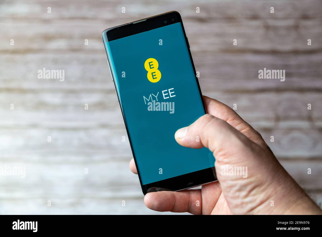 Ein Mobiltelefon oder Mobiltelefon, das/das gehalten wird, zeigt das an EE Mobile App auf dem Bildschirm geöffnet Stockfoto