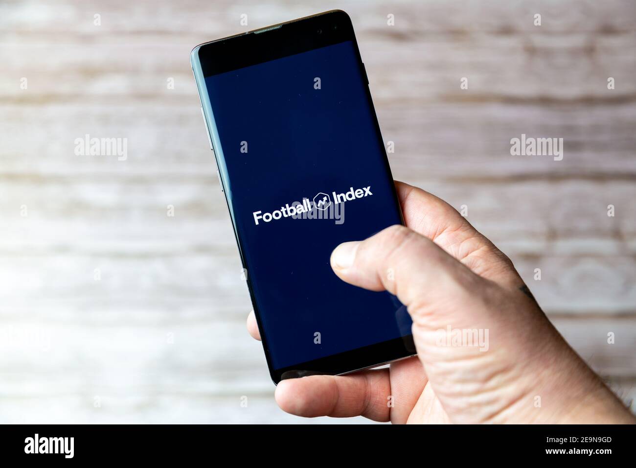 Ein Mobiltelefon oder Mobiltelefon, das/das gehalten wird, zeigt das an Football Index Trading App auf dem Bildschirm geöffnet Stockfoto