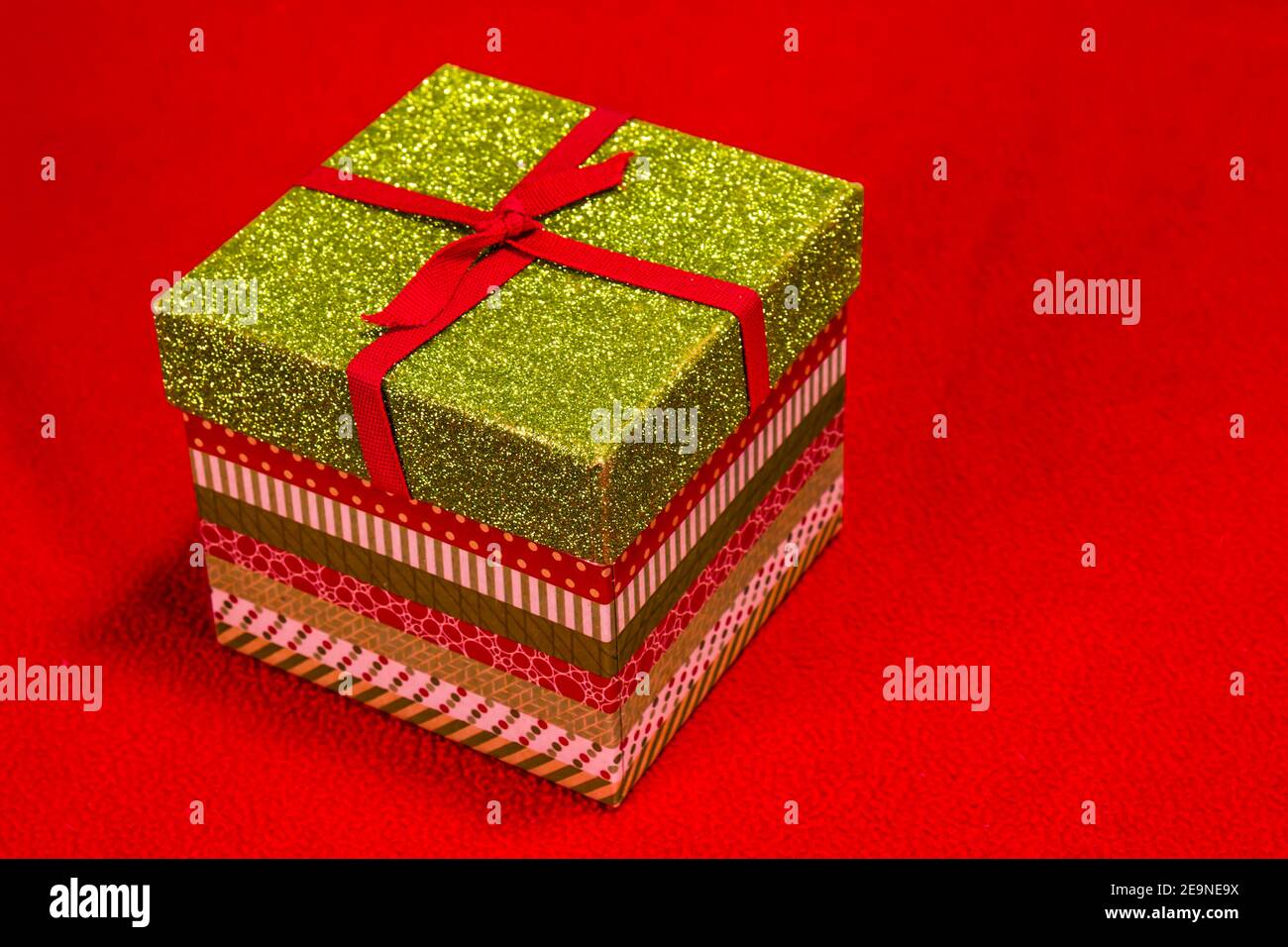 Mehrfarbige Weihnachts-Geschenkbox Auf Rotem Hintergrund Stockfoto