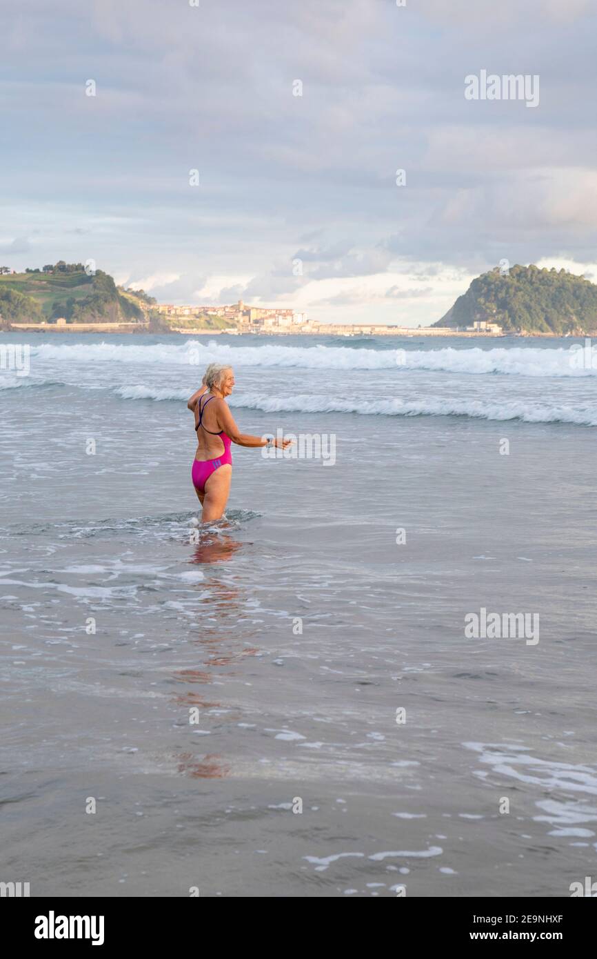 Europa, Spanien, Gipuzkoa, Zarautz Strand mit schönen älteren Frau Baden im Morgengrauen Stockfoto