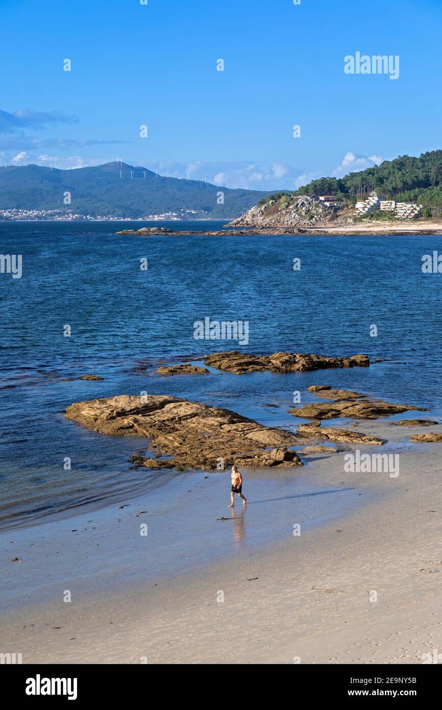 Europa, Spanien, Galizien, Porto do Son, Strand mit Mann, der während der Pandemie Covid-19 im Sommer 2020 eine schützende Gesichtsmaske trägt Stockfoto