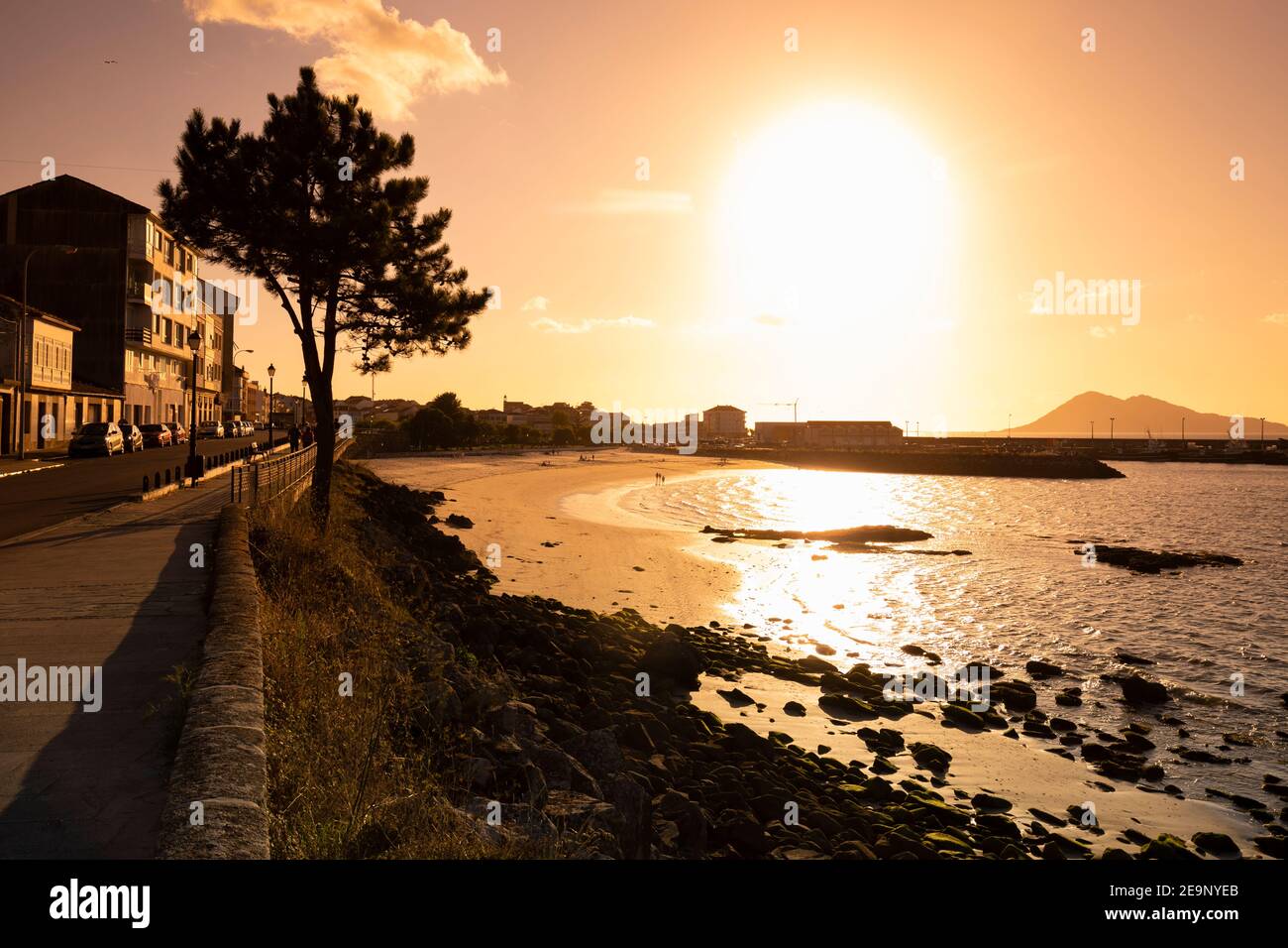 Europa, Spanien, Galizien, Porto do Son, Stranduntergang mit entfernter Hafenmauer Stockfoto