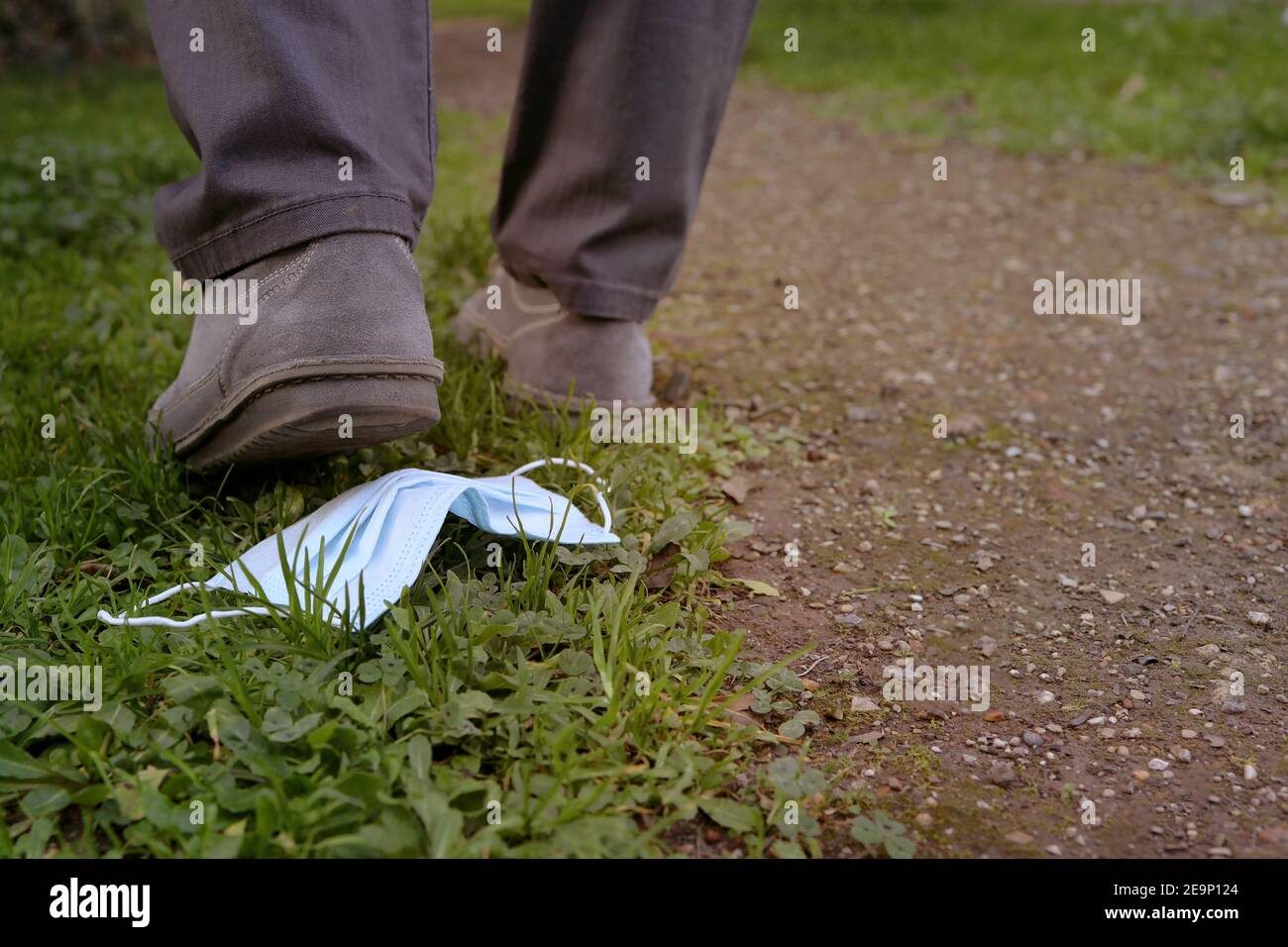 Eine Nahaufnahme Medizinische Schutzmaske auf den Boden geworfen. Abfalleimer medizinische Gesichtsmaske auf der Straße. Stockfoto