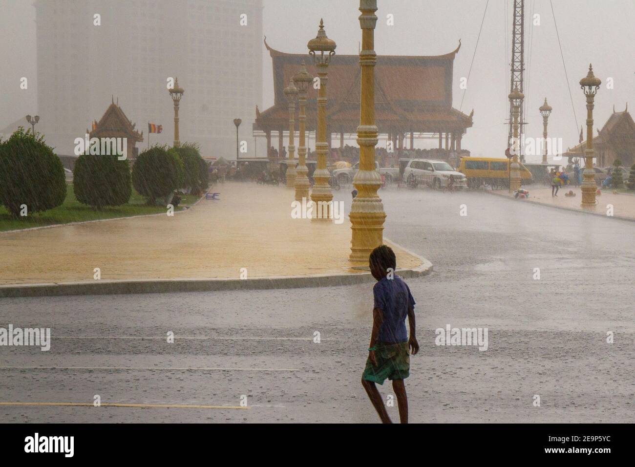 Phnom Penh, Kambodscha - 19. Juni 2016: Ein Junge ist in den Monsunregen von Phnom Penh getränkt. Stockfoto