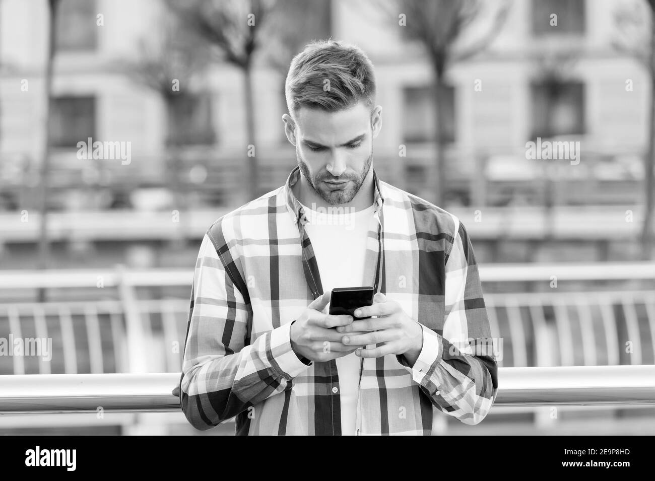 Senden von Instant SMS an jedes Mobiltelefon der Welt. Schöner Mann lesen SMS im Smartphone. SMS-Nachrichten. Mobile Kommunikation. Neue Technologie. Modernes Leben. 3G. 4 G SMS an Kurznachricht senden. Stockfoto