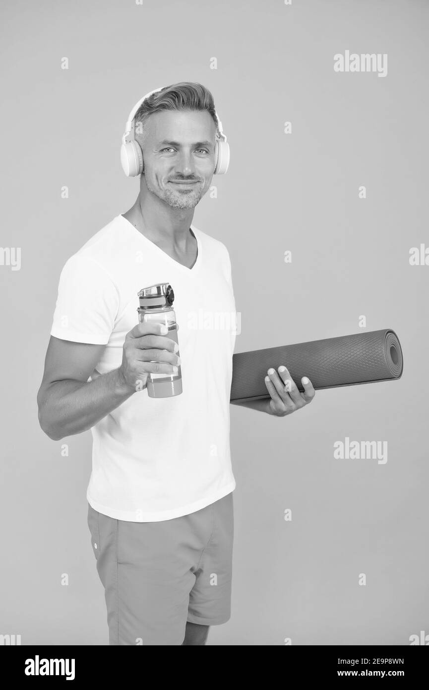 Muskulöser Mann trainiert zu Hause mit Sportmatte, gesundes Lifestyle-Konzept. Stockfoto