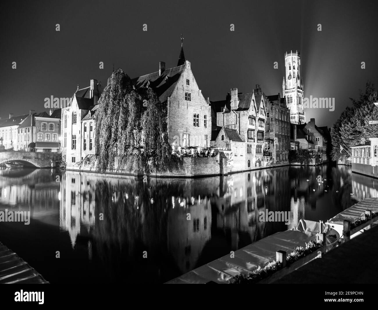 Das Dock des Rosenkranzes - Rozenhoedkaai - und Belfort Turm bei Nacht, Brügge, Belgien. Schwarzweiß-Bild. Stockfoto