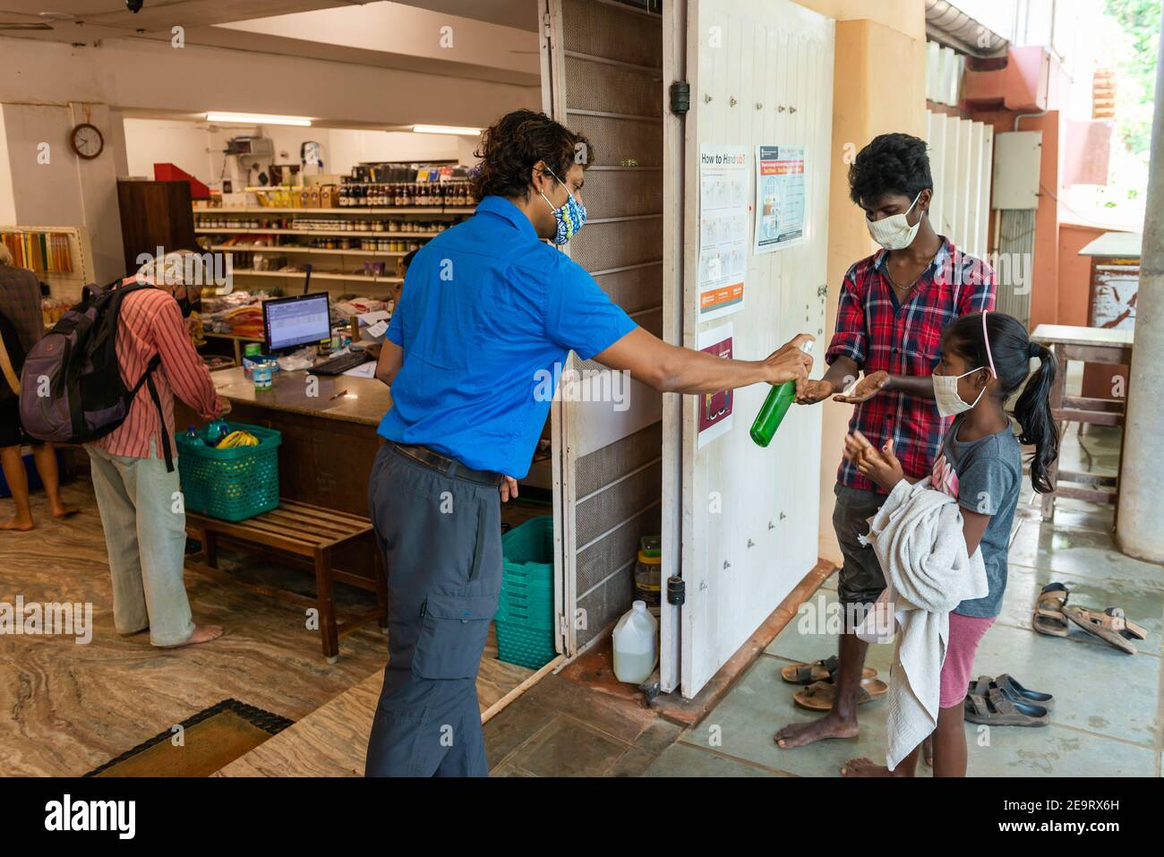 AUROVILLE, INDIEN - 3. April 2020: Hände putzen, bevor man in einen Minimarkt eintritt, um während der Sperre, die durch das Coronavirus verursacht wird, Nahrung zu bekommen. Stockfoto