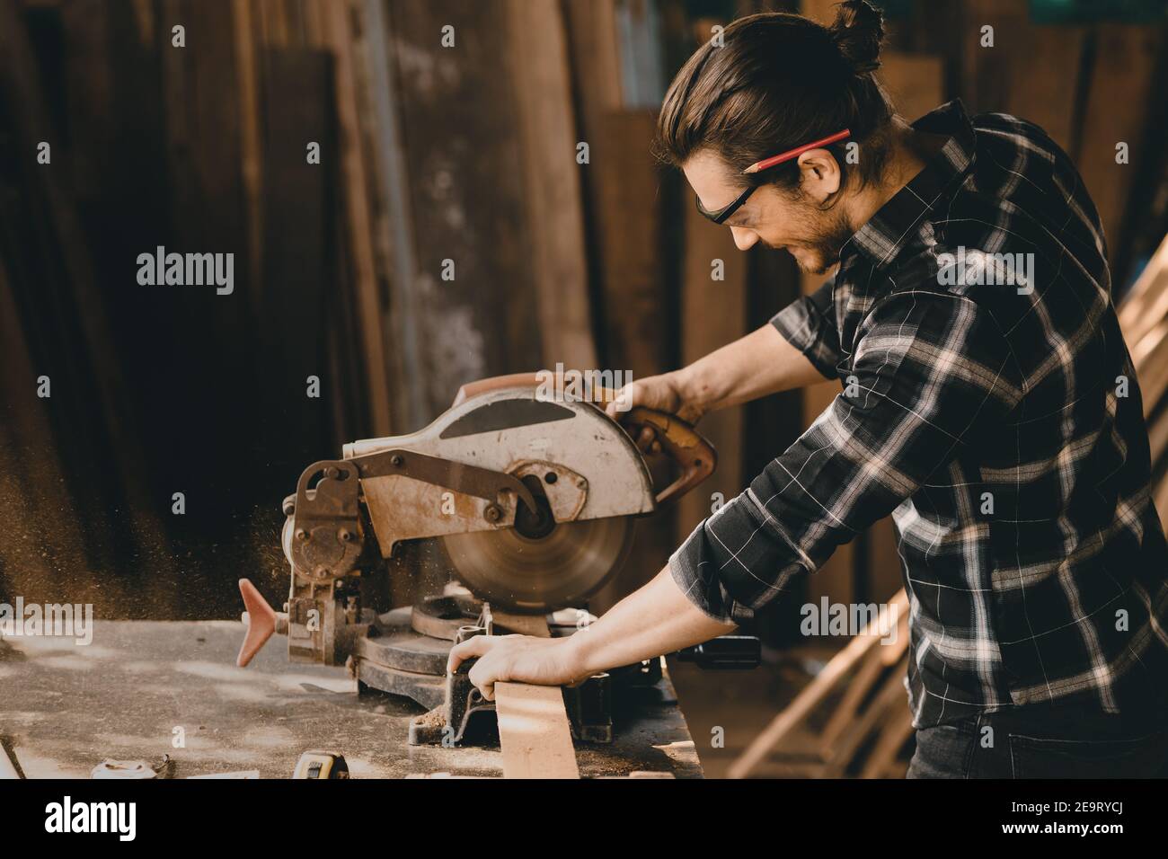 Zimmermann mit Elektro-Holzschneider Holzarbeiten in Möbel Holz-Werkstatt mit professioneller Fähigkeit echte Menschen workman.image enthalten Lärm Stockfoto