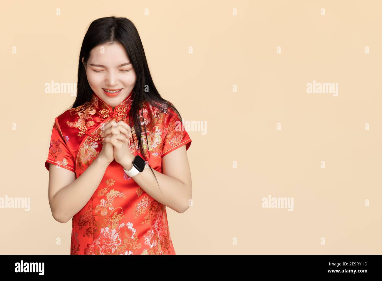 Chinesische Frauen kleiden Qipao traditionellen Tuch machen einen Wunsch oder beten in chinesischen Neujahrsfest mit Kopieplatz. Stockfoto