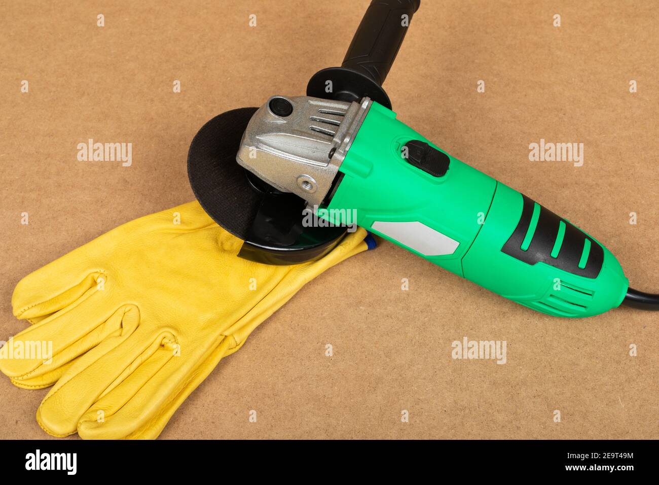 Bild eines grünen Winkelschleifers auf einem Holzhintergrund Stockfoto