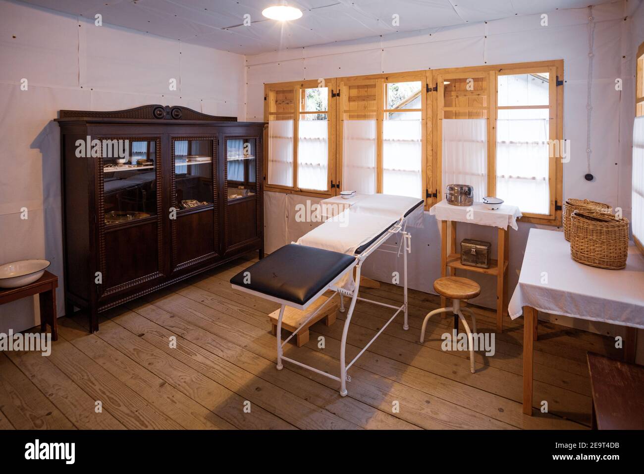 Eine alte Arztpraxis mit einem Arzttisch, Schrank, Stuhl und anderen  medizinischen Hilfsgütern Stockfotografie - Alamy