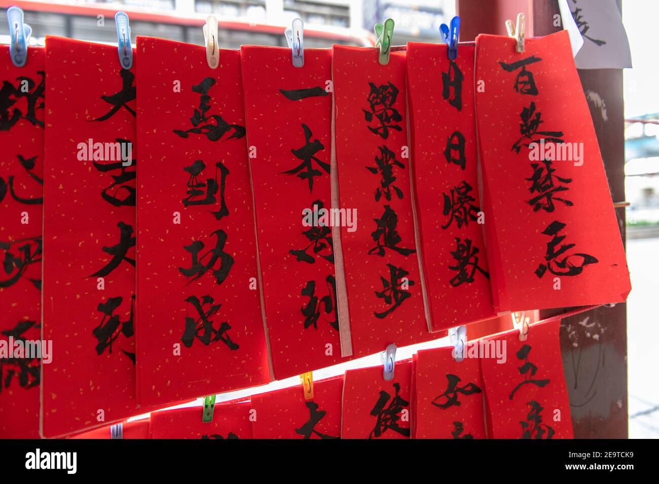 Hongkong, China. Februar 2021, 06th. HONGKONG, HONGKONG SAR, CHINA: FEBRUAR 6TH 2021. Eine Kalligraphie sifu (Meister) arbeitet an der Seite einer belebten Straße in Causeway Bay Hongkong und produziert handbemalte kantonesische Couplets, die für das chinesische Neujahr bereit sind. Mondneujahrescouplets oder Cheun lyun, werden als Dekoration verwendet und haben unterschiedliche glückverheißende Nachrichten, die auf ihnen geschrieben werden. CNY beginnt am Freitag, 12th. Februar 2021 mit dem Feiertag, der das Tierkreisjahr des Ochsen ankündigt Alamy Live News/Jayne Russell Credit: Jayne Russell/Alamy Live News Stockfoto