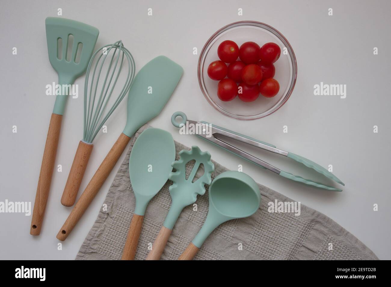 Set mit Küchenutensilien und Kirschtomate auf weißem Hintergrund - direkt darüber Stockfoto