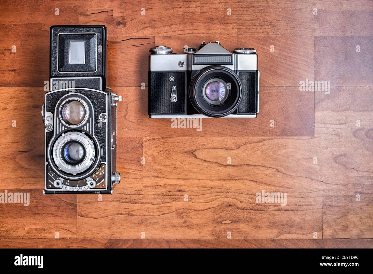 Eine alte Mittelformat-Spiegelreflexkamera und eine alte Spiegelreflexkamera 35mm, von oben gesehen horizontales Format mit Kopierraum Stockfoto
