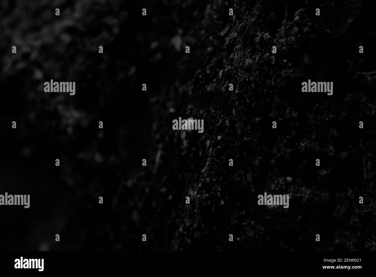 Abstraktes geometrisches Muster aus schwarzem Stein aus einer alten Steinwand in schwarz und weiß - Textur, Hintergrund oder Tapete für Fotomontage Stockfoto