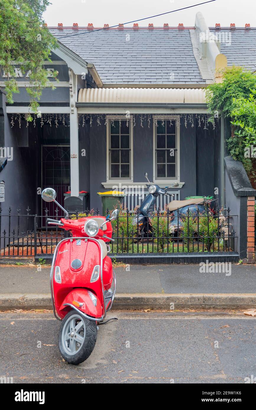 Eine kleine Doppelhaushälfte Federation Stil einstufige Terrasse Haus mit zwei Motorroller vor geparkt, in Newtown, New South Wales, Australien Stockfoto