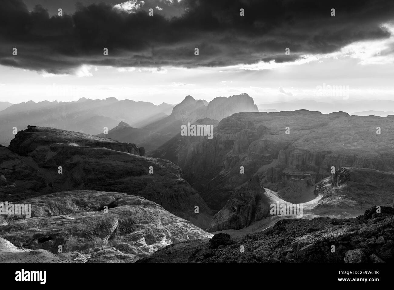 Dramatischer Wolkenhimmel, Sonnenlicht st Sonnenuntergang auf der Sellagruppe. Die Dolomiten. Italienische Alpen. Schwarz weiße Berglandschaft. Stockfoto