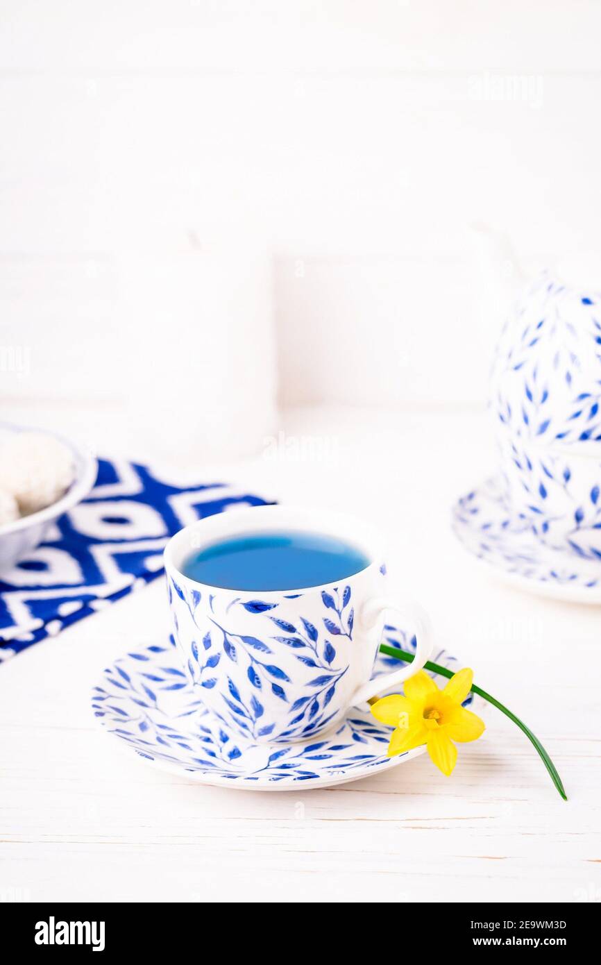 Tasse mit Blättern Muster aus blauem Tee und kleine Narzissen, kopieren Raum Stockfoto