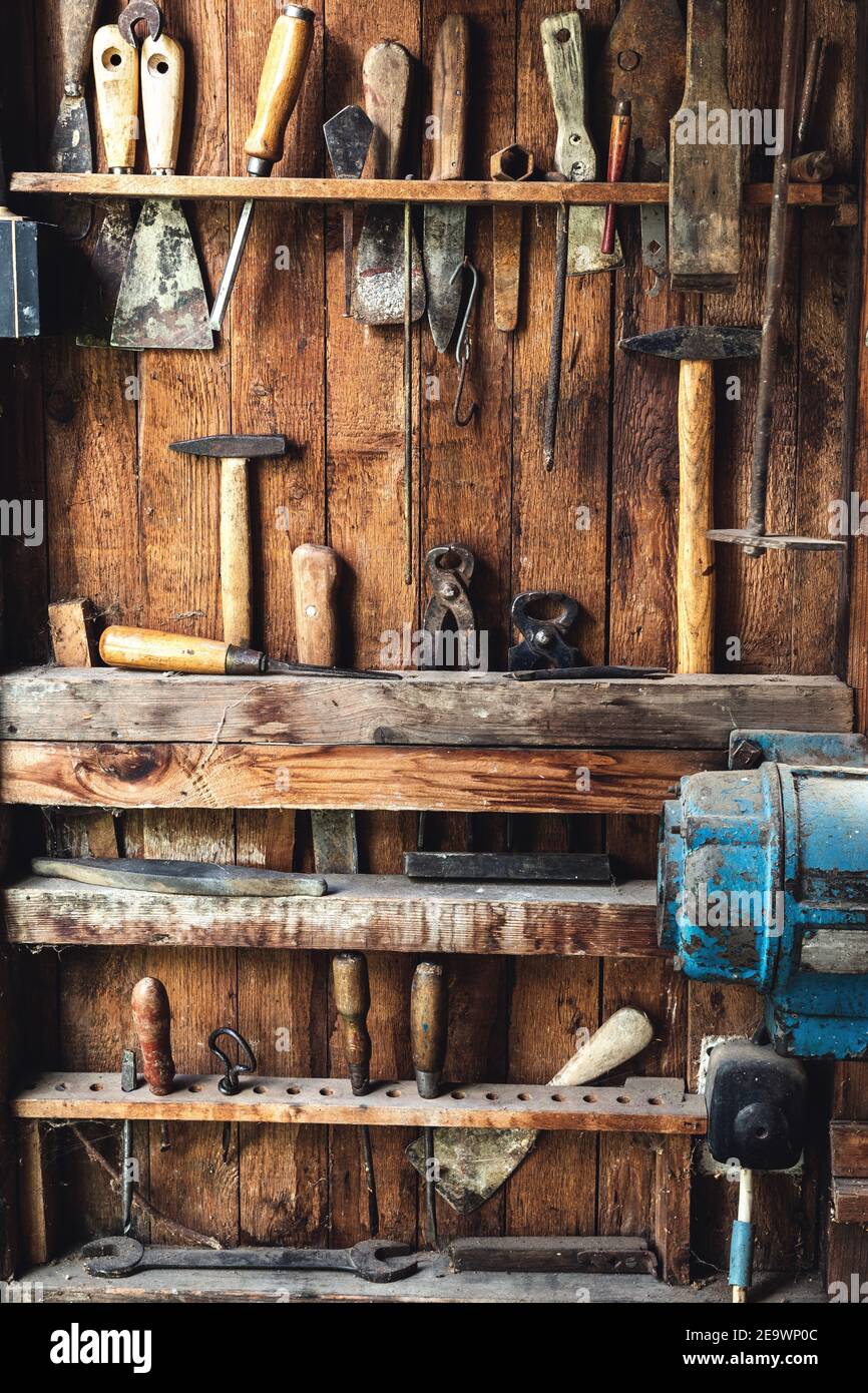Retro-Arbeitswerkzeug in der Schreinerei. Variation von Zangen, Hammer, Schraubendreher, Meißel, Bohrer und andere Handwerkzeuge in Holz Hintergrund Stockfoto