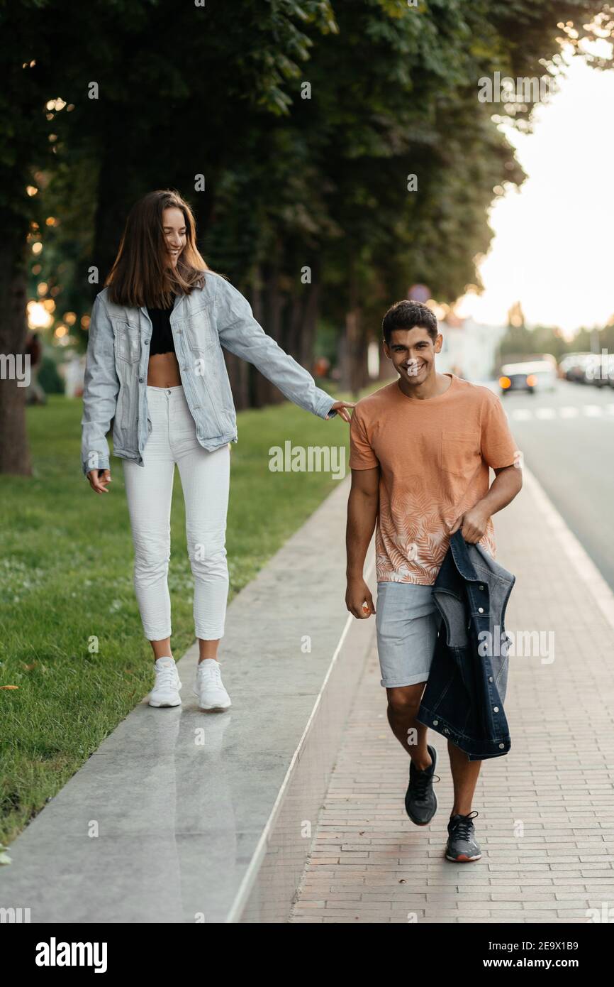 Fröhliches Paar, das gerne in der Stadt spazieren geht. Zwanglose Menschen. Verliebte Paare in der Stadt. Urbane Liebesgeschichte Stockfoto