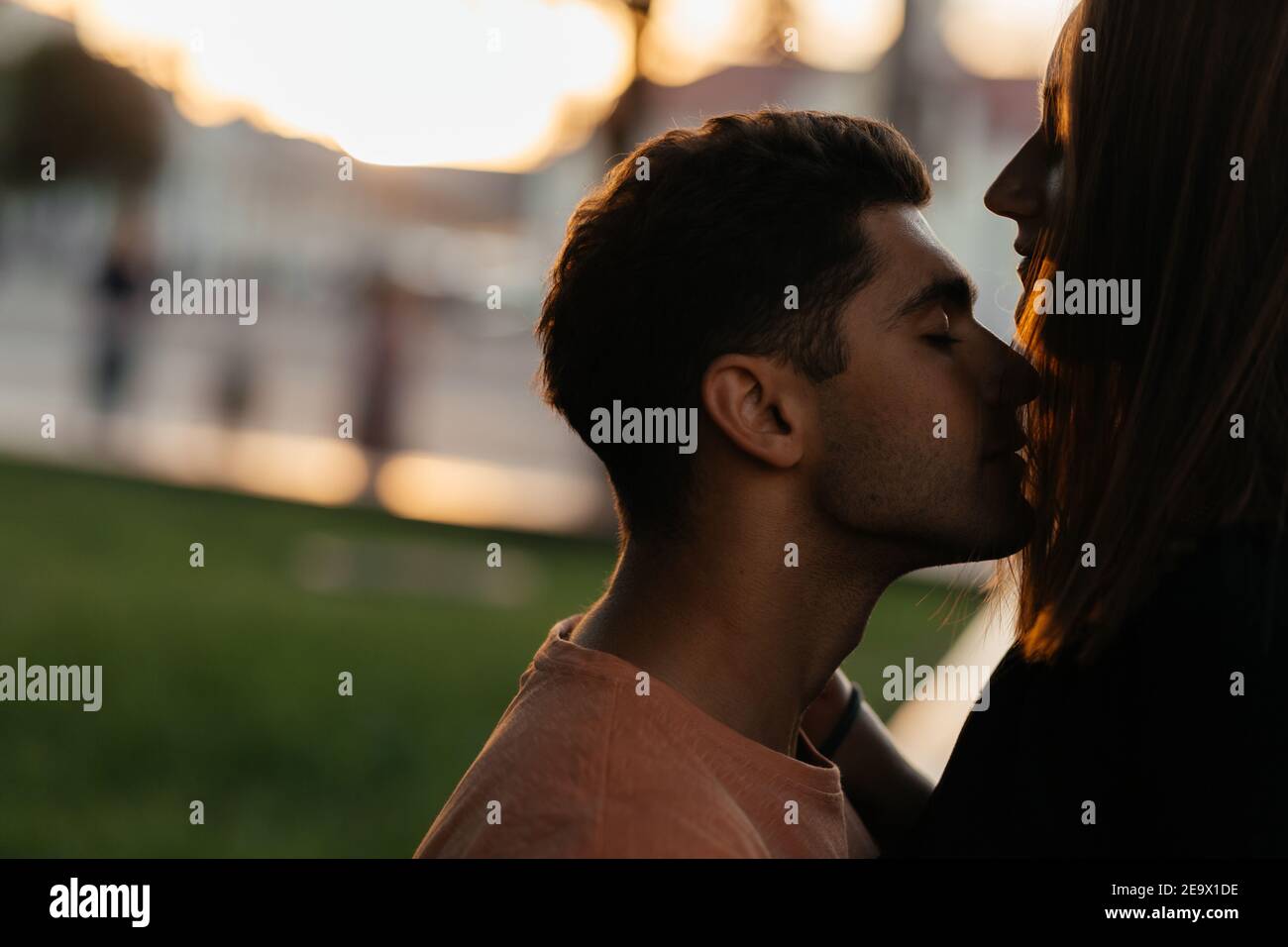 Silhouetten von jungen Paar, die auf dem unscharfen Hintergrund mit Platz für Ihren Text intim. Verliebte Paare in der Stadt. Urbane Liebesgeschichte Stockfoto