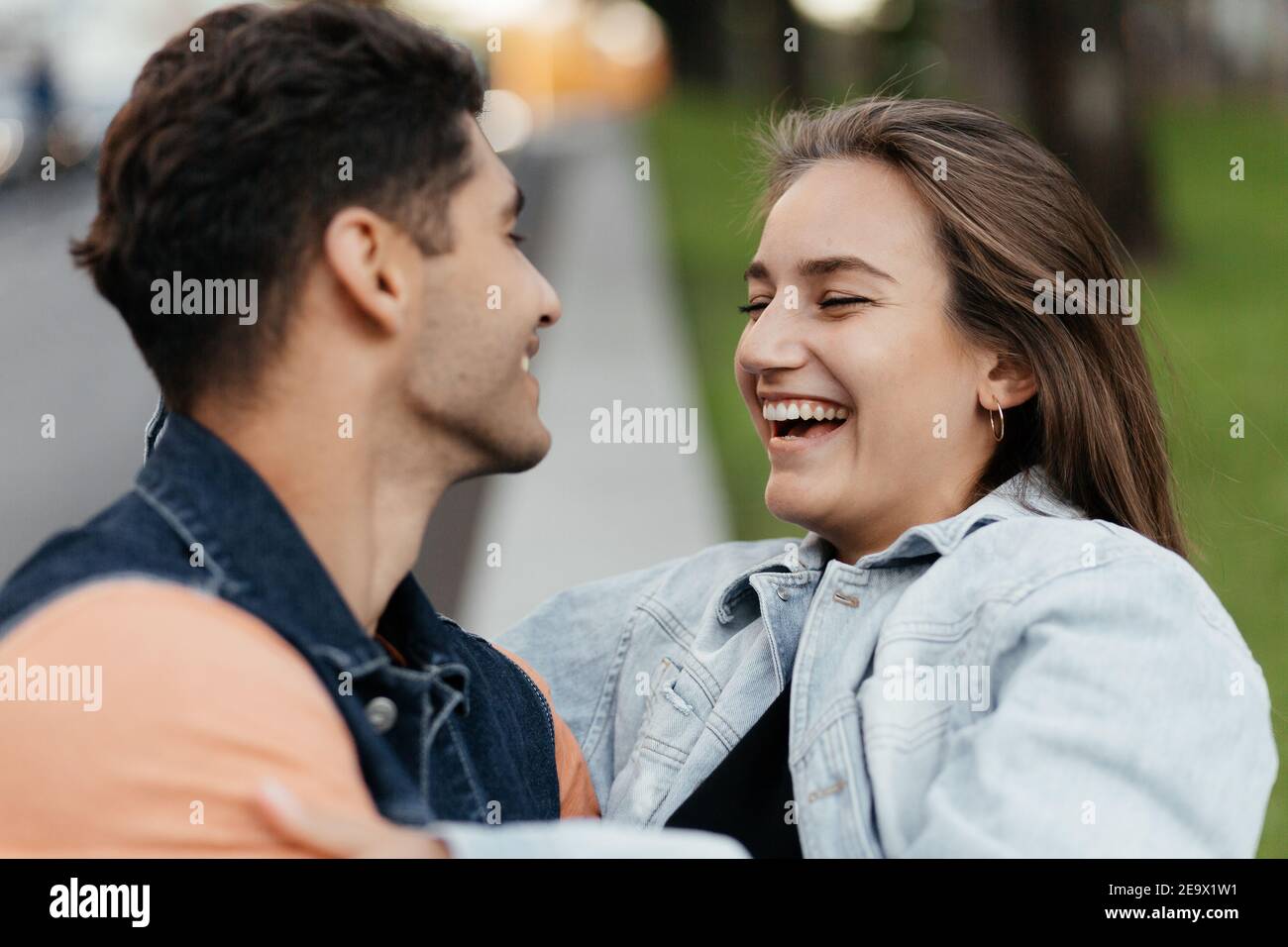 Junge Liebhaber im lässigen Stil haben Spaß auf der Straße. Mann und Frau lachen. Verliebte Paare in der Stadt. Urbane Liebesgeschichte Stockfoto